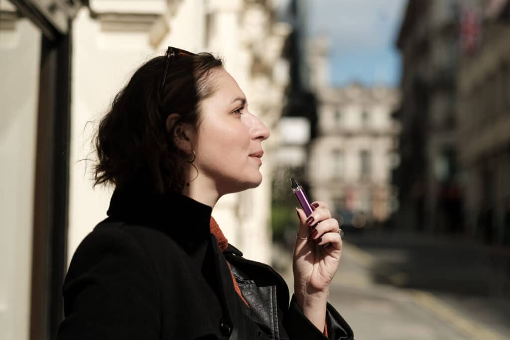 Woman using a vape outdoors